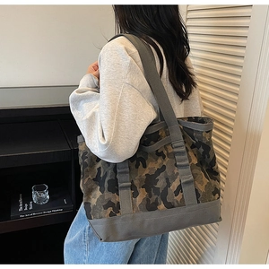 Détail du sac en toile camouflage gris montrant les coutures renforcées de la bandoulière
