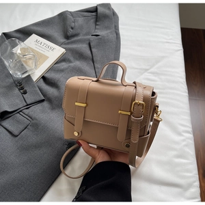 Detail of vintage khaki leather square crossbody bag with gold hardware and top handle