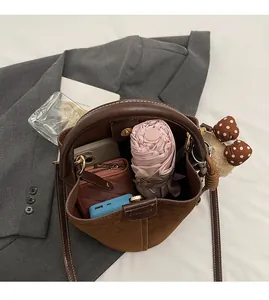 Vista interior que muestra la gran capacidad del bolso saco marrón vintage con objetos diarios
