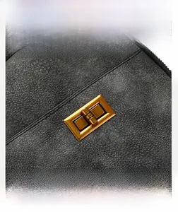 Close-up of vintage bronze twist lock on premium dark grey suede backpack fabric