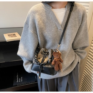 Detalle del bolso tipo cubo coreano con bordado de estrellas y colgante de osito pardo