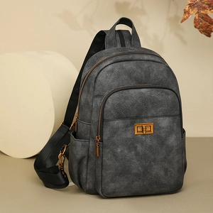 Detail of grey vintage backpack with gold hardware and secure front twist-lock closure