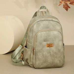 Detail of light green pebbled leather backpack with gold twist lock and side pockets