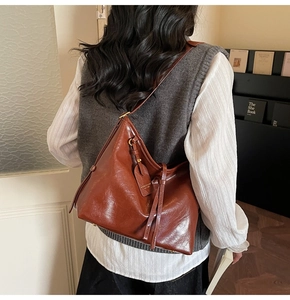 Minimalist vintage brown leather hobo shoulder bag styled on a female model