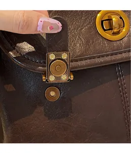 Close-up of the vintage brown leather texture and the magnetic buckle on the backpack