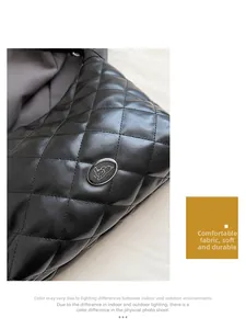 Close-up of black quilted leather tote bag with embroidery details and oval metal tag