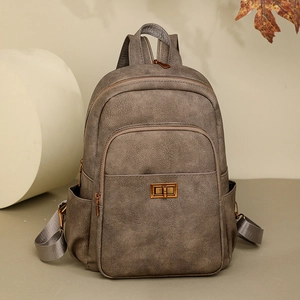 Detail of vintage dark brown leather backpack with bronze metal clasp and multiple pockets