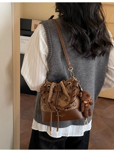 Bolso saco retro marrón con relieve floral y un colgante de oso de peluche suave