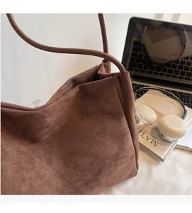 Détail montrant la texture en daim marron doux et l'anse fine du sac léopard chic