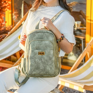 Retro moss green lady backpack with golden turn-lock and adjustable straps in sunlight