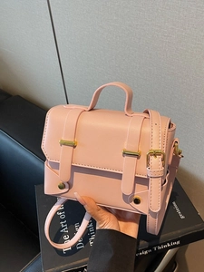 Minimalist light pink square handbag with gold hardware and adjustable crossbody strap