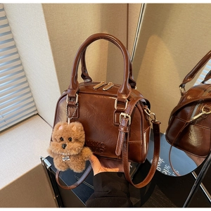 Macro view of vintage brown bowling bag with glossy texture and plush dog charm