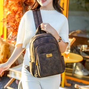 Detail of vintage brown textured backpack with gold metal twist lock and side pocket