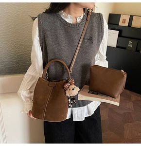 Bolso tipo cubo de gamuza vintage marrón con un colgante de oso de peluche y mini estuche