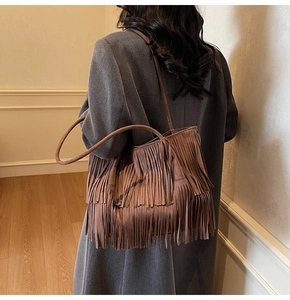 Borsa tote marrone con frange a strati portata a spalla in un ambiente domestico