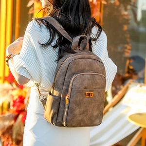 Detailed view of vintage dark brown leather backpack with gold clasp and textured finish