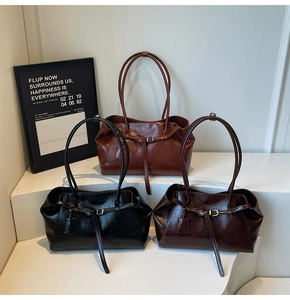 Close-up of retro leather tote bags in black and brown finishes on a display stand