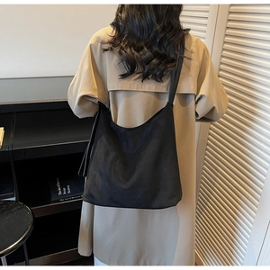 Model view of a large black matte hobo bag showcasing its casual drape and minimalist style