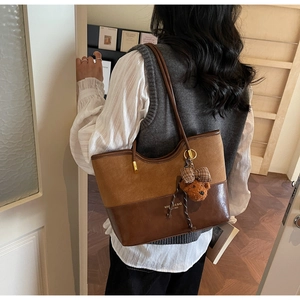 Dettaglio borsa tote patchwork vintage con trama scamosciata e ciondolo a forma di orso