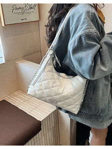 Detail of white quilted leather hobo bag with gold chain strap and metal rabbit logo