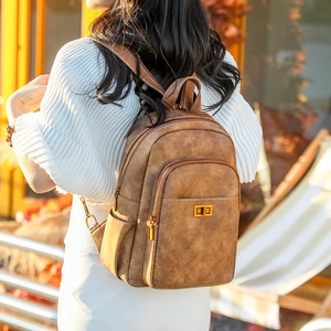 Detail of vintage brown textured leather backpack with gold metal clasp and zipper