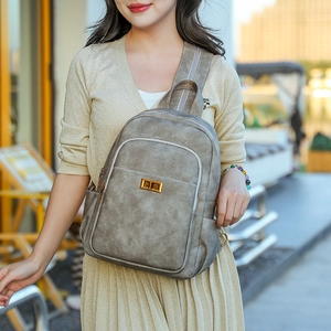 Close-up of gray faux leather backpack with vintage texture and gold twist-lock buckle
