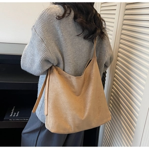 Detail of adjustable leather strap and soft suede texture on camel tote bag shoulder strap
