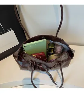 Top view of spacious brown tote interior holding a tablet, wallet and cosmetics