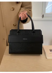 Detail of black crocodile pattern leather tote bag with Fashion & Bag text logo