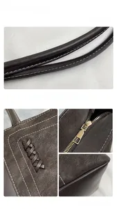 Detail of contrast stitching, woven leather, and suede texture on a brown tote bag