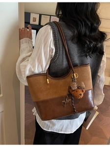 Borsa tote patchwork retrò in pelle e camoscio marrone indossata a spalla da modella