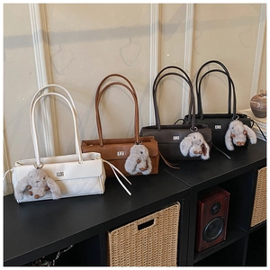 Detail of elegant quilted leather shoulder bags in four colors with plush bunny charms