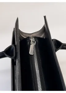 Detail of silver metal zipper and premium stitching on the black leather tote bag