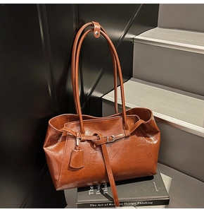 Detail of vintage brown oil-wax leather tote bag texture with elegant hanging tag