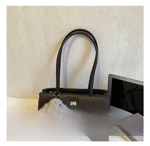 Detail of dark brown baguette bag with gold twist lock and cute plush rabbit charm