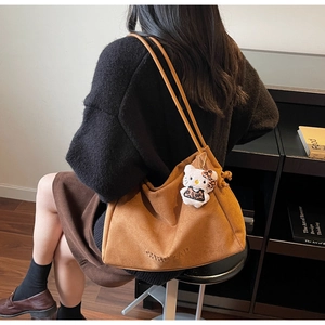 Sac cabas chic en daim marron avec fines bandoulières et détail de breloque de mode