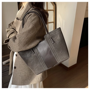 Detail of vintage tote bag featuring decorative white stitching and woven texture accents