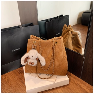 Détail du sac cabas matelassé marron avec chaîne dorée et breloque lapin en peluche