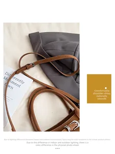 Detail of coffee brown leather tote showing adjustable strap and silver metal buckle