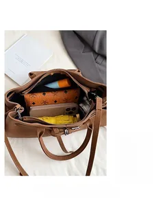 Macro view of a brown pebbled leather tote bag interior showing spacious storage for daily items