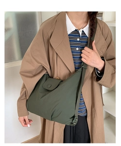 Detail of dark green waterproof nylon crossbody bag with adjustable wide shoulder strap