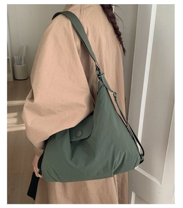 Side view of forest green padded tote bag on a trench coat highlighting the casual style