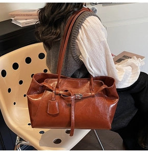 Brown oil-wax leather tote bag showing fine texture and sleek shoulder strap detail