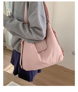 Macro view of pink quilted tote bag showing adjustable strap and flap buckle closure