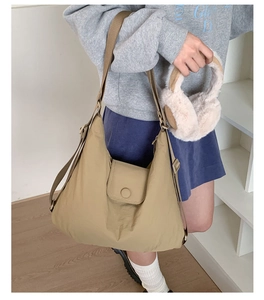 Detail of khaki large capacity tote bag with adjustable wide strap and flap closure design