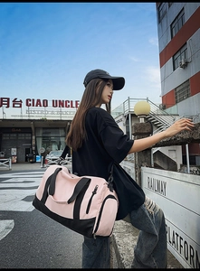 Pink and black sports bag with side shoe compartment and adjustable shoulder strap