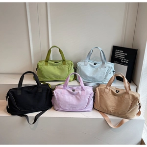 Multi-colored large capacity gym bags and travel duffels displayed on white steps