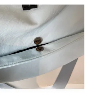 Detail view of cylindrical magnetic clasp on water-ripple textured travel bag fabric