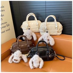 Detailed display of four retro leather pillow bags with cute plush bunny charms in warm studio