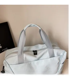 Detail of light blue travel bag featuring reinforced handles and durable two-way zippers